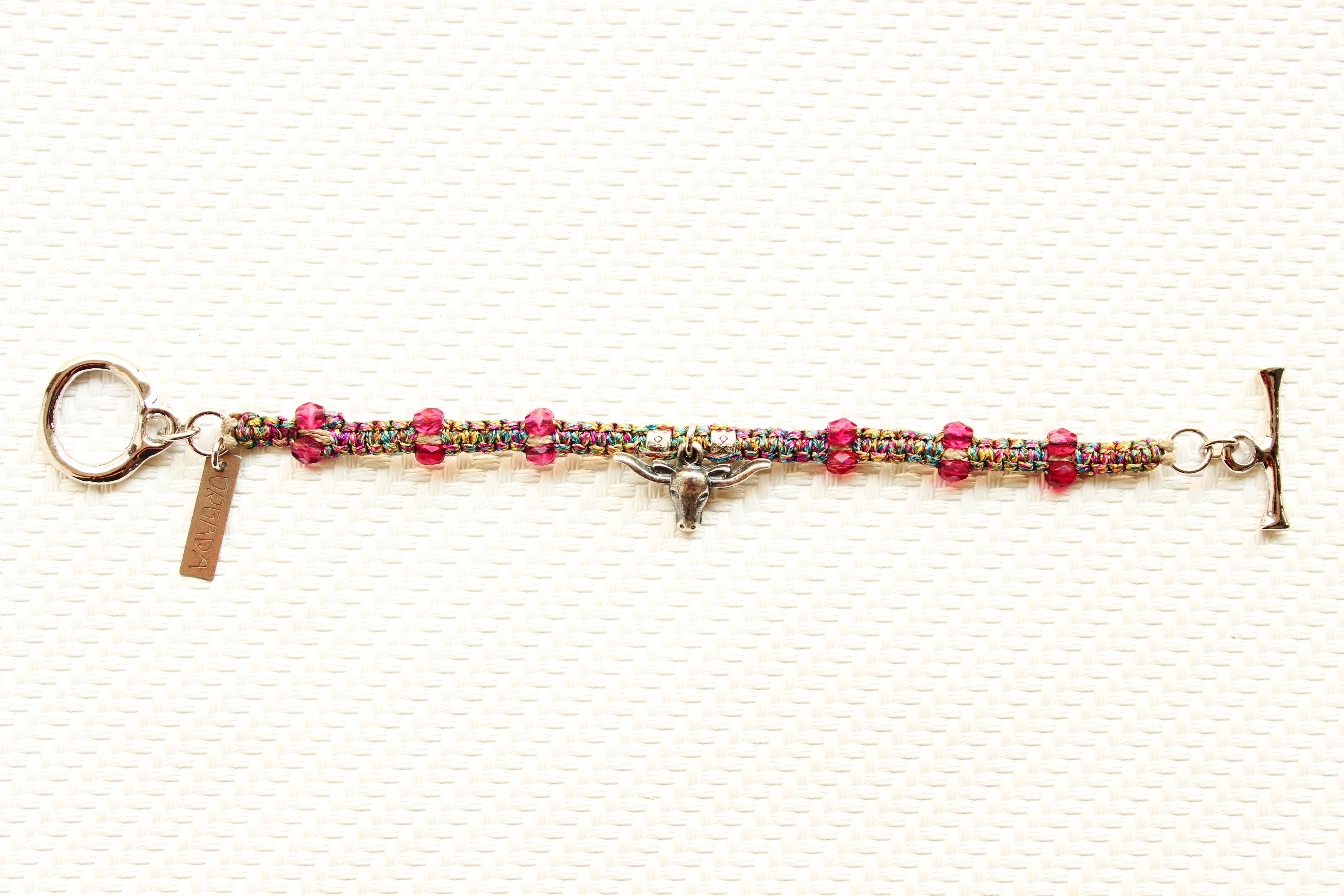 ORGADA's Bullia bracelet made of colourful waxed cords and a bull pendant in a macrame tecnique photographed in full view