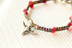 ORGADA's Bullia bracelet made of colourful waxed cords and a bull pendant in a macrame tecnique in close-up. 