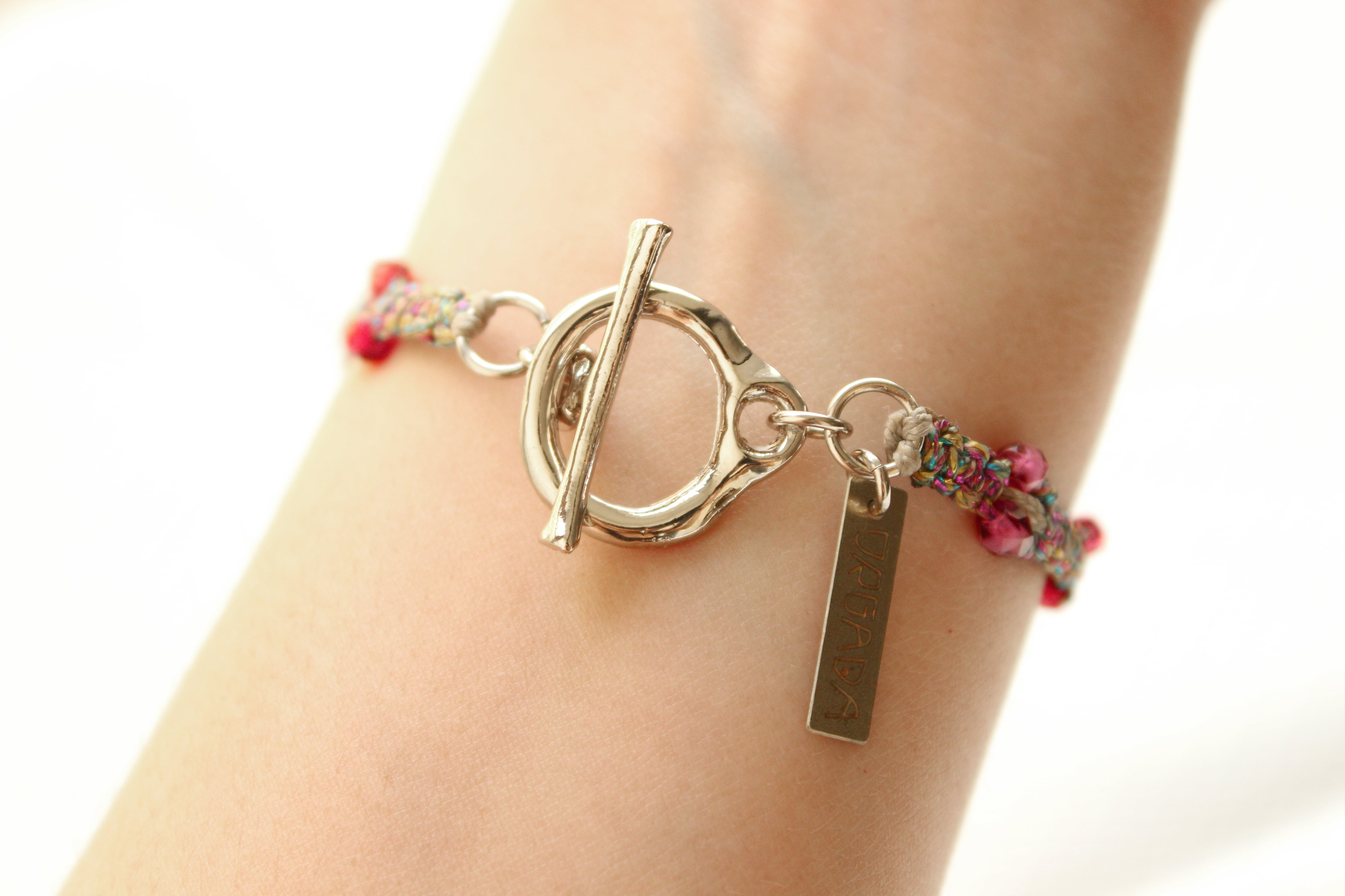 ORGADA's Bullia bracelet made of colourful waxed cords and a bull pendant in a macrame tecnique and a toggle clasp photographed on a wrist.