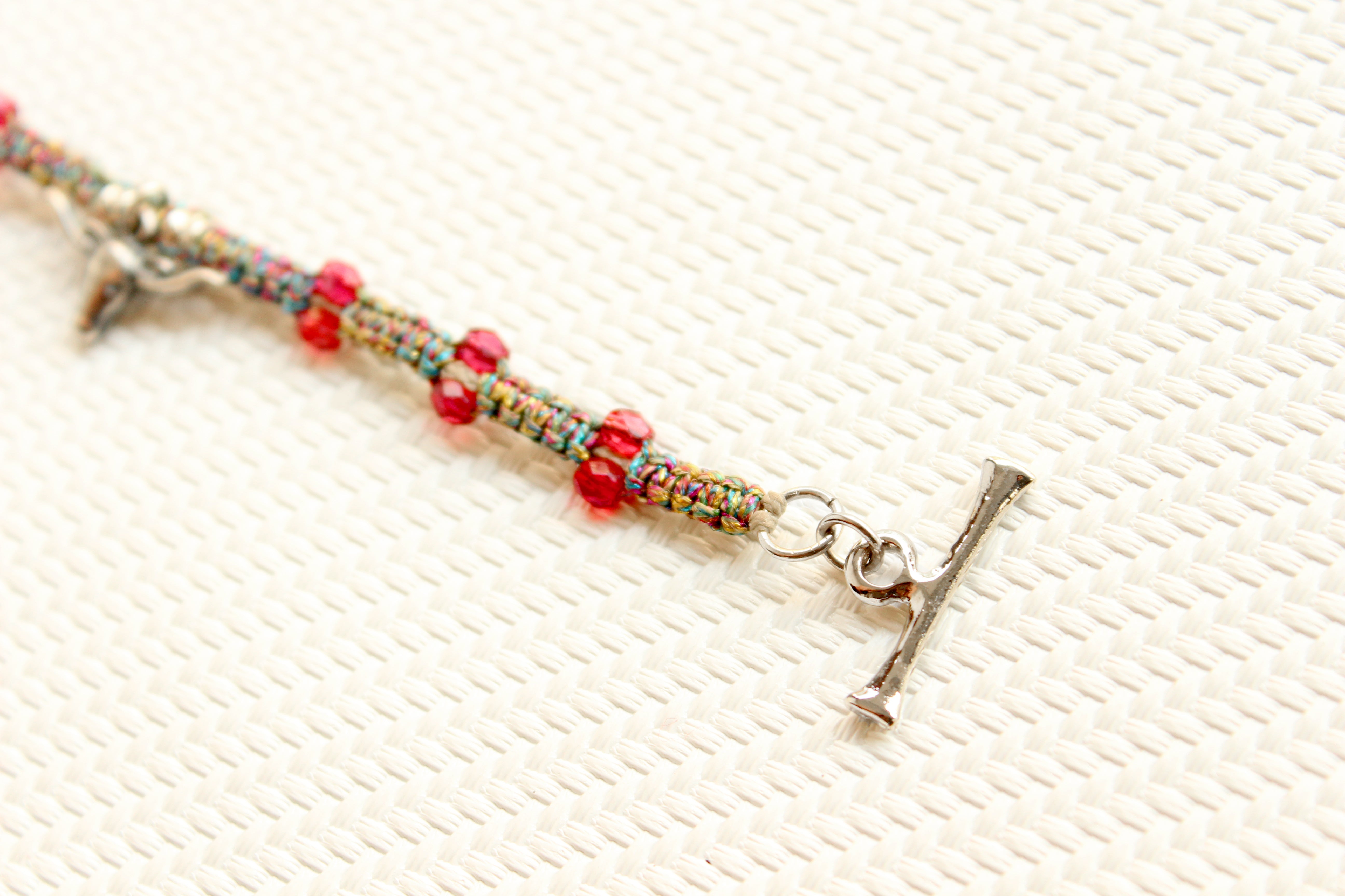 ORGADA's Bullia bracelet made of colourful waxed cords and a bull pendant in a macrame tecnique photographed in close-up