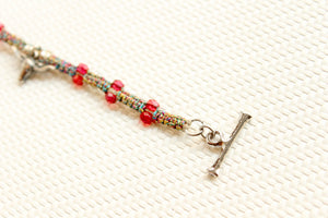 ORGADA's Bullia bracelet made of colourful waxed cords and a bull pendant in a macrame tecnique photographed in close-up