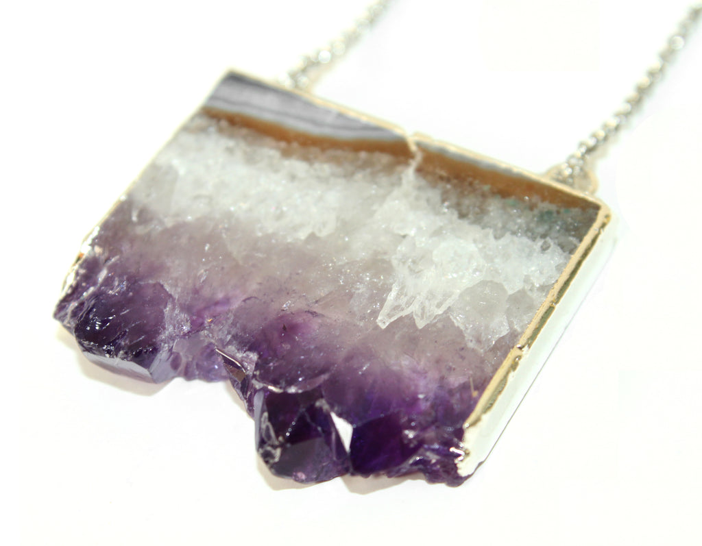 Orgada's boho Orka necklace, designed with a precious Amethyst stone and is related to the third eye chakra, on a white background in close up