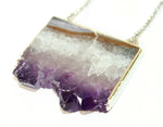 Orgada's boho Orka necklace, designed with a precious Amethyst stone and is related to the third eye chakra, on a white background in close up