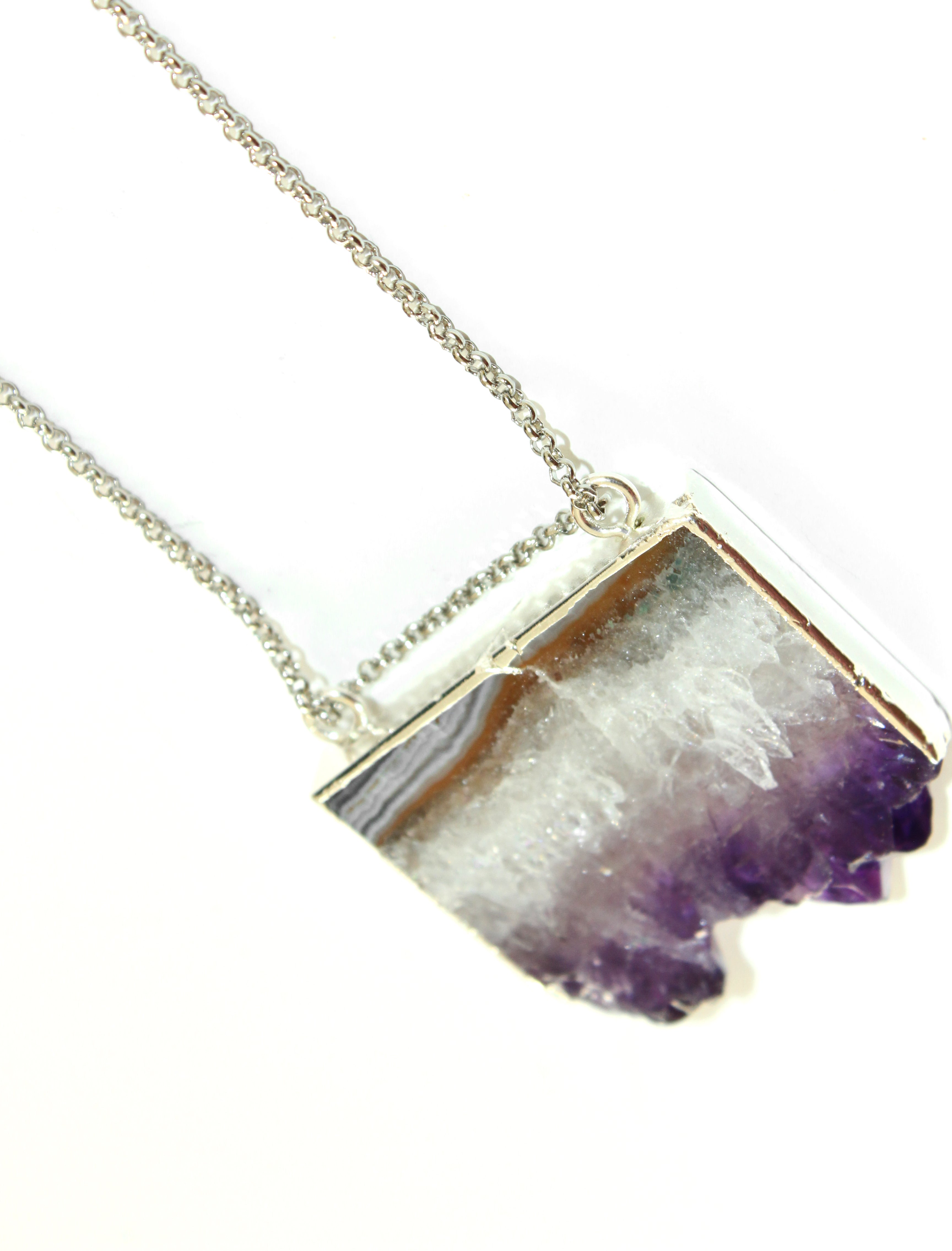 Orgada's boho Orka necklace, designed with a precious Amethyst stone and is related to the third eye chakra, on a white background 